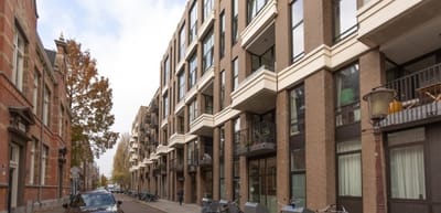 Exterior view of a modern building with balconies and trees