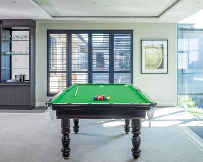 A well-lit interior game room with a pool table