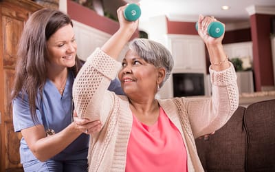 A caregiver assisting a resident with weights in a cozy room