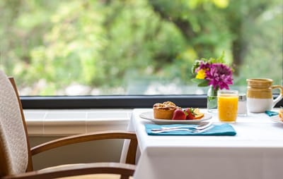 A beautifully set table with breakfast items and flowers
