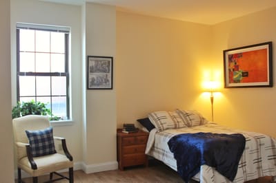 Cozy private resident room with a bed and chair