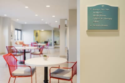 Bright common area with seating and informational sign