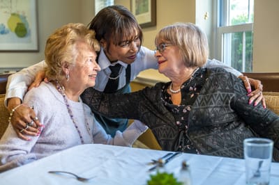 A caregiver sharing a moment with two residents