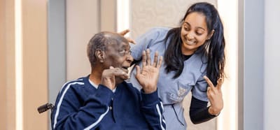 A resident and staff member smiling and interacting