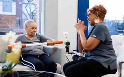 Therapist assisting resident with physical therapy exercises