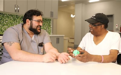 Staff member engaging with resident in a bright room