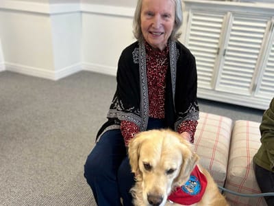 Resident interacting with a dog in a common area