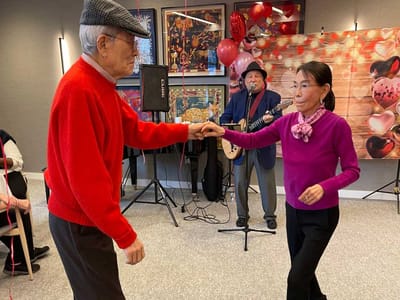 Two residents dancing at a celebration with live music