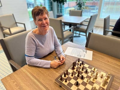 Resident enjoying a game of chess in the common area