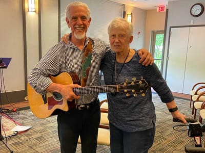 Resident smiling with musician during an activity