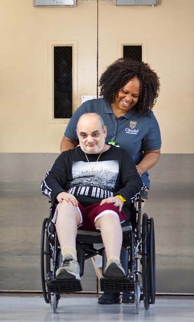 A staff member assisting a resident in a wheelchair