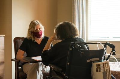 Staff member engaging with a resident in a private room