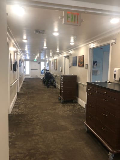 Interior hallway with artwork and a wheelchair