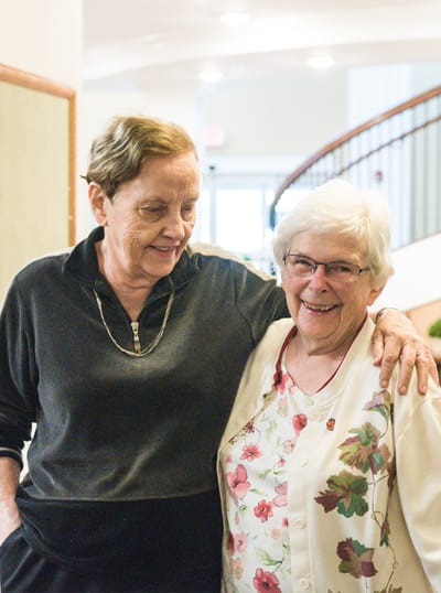 Two residents smiling and interacting in an interior space