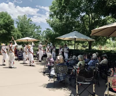 Residents enjoying an outdoor performance by staff