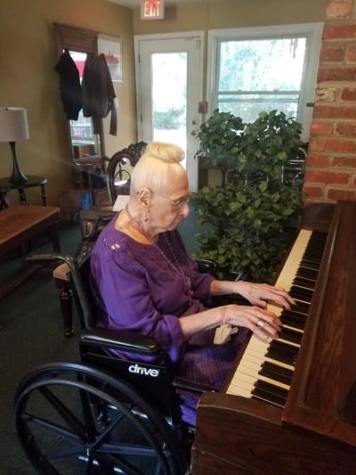 Resident playing piano in a common area
