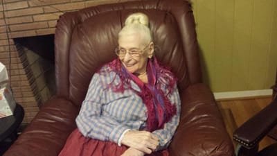An elderly woman sitting comfortably in a chair