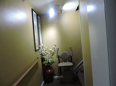 Interior hallway with a stairlift and decorative plants