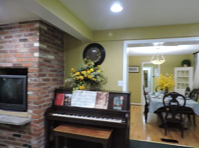Interior of a common area with a piano and dining space