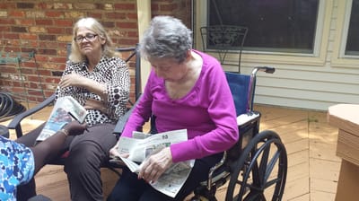 Two residents engaged in conversation on a patio