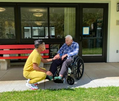 Staff interacting with a resident in a garden area