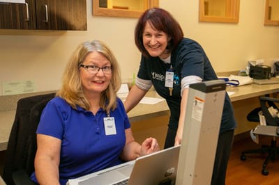 Staff assisting residents at a reception desk