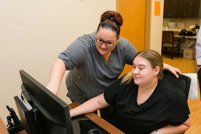 Two staff members engaged at a computer