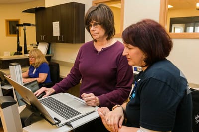Staff helping residents with technology in a common area