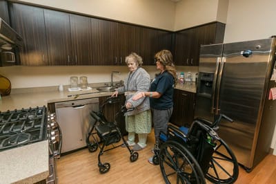 Staff assisting a resident in a kitchen area