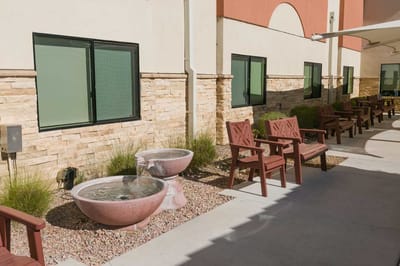Outdoor seating area with a fountain and garden.