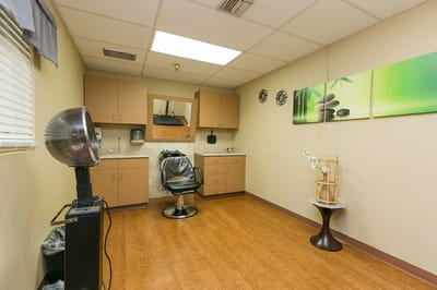 Hair salon interior with styling chair and storage cabinets