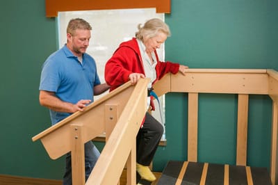 Staff assisting a resident with mobility in an indoor setting