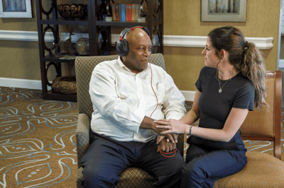Resident enjoying music therapy with staff member