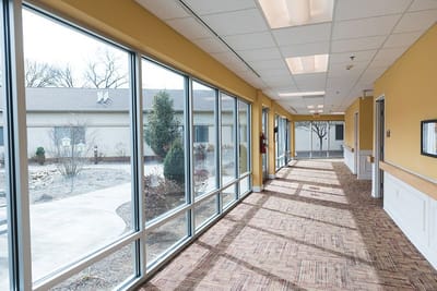 Brightly lit corridor with large windows and carpeted floor