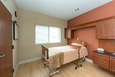 Interior view of a resident room with bed and furniture