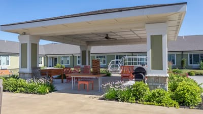 Outdoor seating area with shaded pergola and gardens
