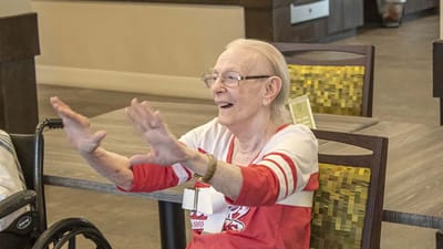 Resident joyfully engaging in an activity inside the facility