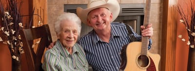 A resident and staff member enjoying music together