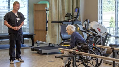 Therapist assisting an elder in a rehabilitation facility