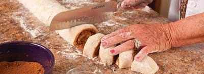 A resident preparing dough on a kitchen countertop