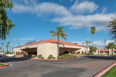 Exterior view of Mi Casa Nursing Center with palm trees