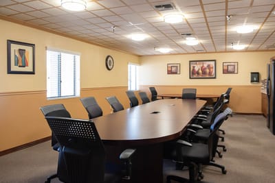 A well-lit conference room with a large table and chairs