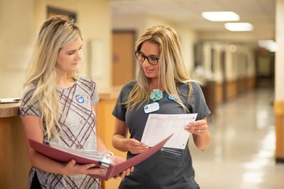 Staff members reviewing documents in a hallway