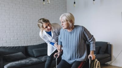 A caregiver assisting a resident in a cozy lounge.