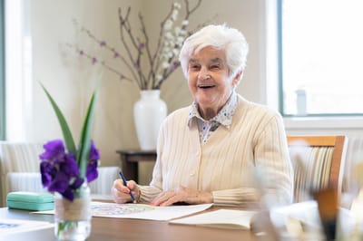 Resident enjoying a coloring activity in an interior space