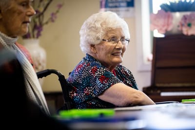 Resident smiling and engaging in an activity indoors