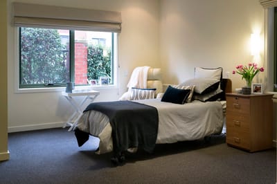 Cozy resident room with bed and flower vase