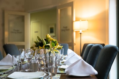 Dining room set up for a meal with flowers on the table