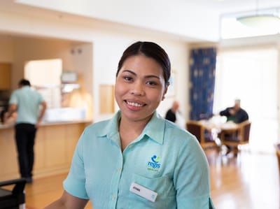 Staff member smiling in an interior dining area