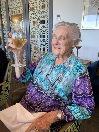 A resident enjoying a drink and smiling